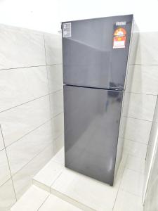 a refrigerator is sitting on a tile floor at Happy Vacation Homestay Mersing 2 in Mersing
