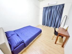a bedroom with a blue bed and a desk and a chair at Happy Vacation Homestay Mersing 2 in Mersing