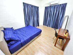 1 dormitorio con cama azul y escritorio en Happy Vacation Homestay Mersing 2 en Mersing