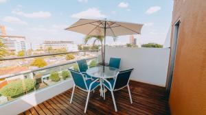 balcón con mesa, sillas y sombrilla en Hotel Seven Monteria, en Montería