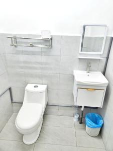 a white bathroom with a toilet and a sink at Happy Vacation Homestay Mersing 2 in Mersing