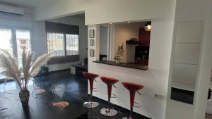 uma sala de estar com bancos vermelhos e um espelho em Seaty Apartment em Corinto