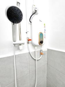 a shower in a bathroom with a phone on the wall at Happy Vacation Homestay Mersing 2 in Mersing