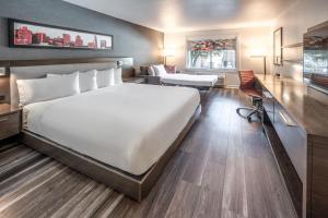 サンノゼにあるアロフト サン ノゼ クパチーノの大きなベッドとデスクが備わるホテルルームです。