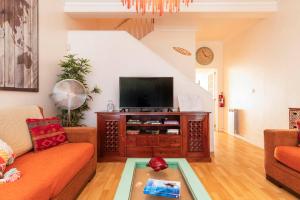 ein Wohnzimmer mit einem Sofa und einem Flachbild-TV in der Unterkunft Nesha Guesthouse Lisbon in Lissabon