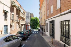 ulica miejska z samochodami zaparkowanymi po stronie drogi w obiekcie Bowie House - Madrid River-A-SALVAD w Madrycie