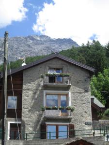 a building with a balcony with flowers on it at Al Bait de Giò in Bormio
