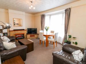 - un salon avec un canapé et une table avec une cheminée dans l'établissement Flat 2, à Teignmouth