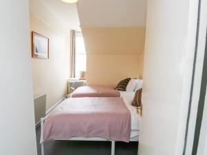 Cette petite chambre comprend 2 lits et une fenêtre. dans l'établissement Flat 2, à Teignmouth