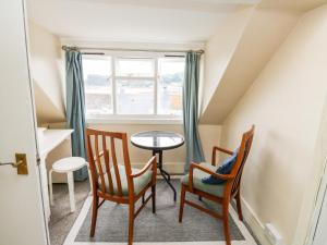une chambre avec une table, deux chaises et une fenêtre dans l'établissement Flat 2, à Teignmouth