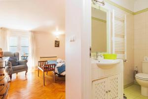 a bathroom with a sink and a toilet and a living room at Nesha Guesthouse Lisbon in Lisbon