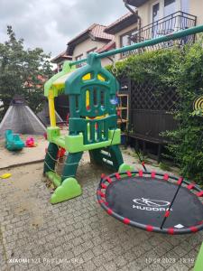 um parque infantil com um bambolê num quintal em Villa Zosia em Rowy