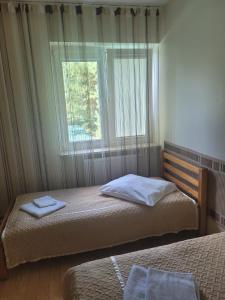 1 dormitorio con 2 camas y ventana en Albert Turystyczne Usługi Hotelarskie en Varsovia