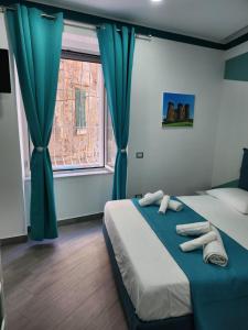 Schlafzimmer mit einem Bett mit blauen Vorhängen und einem Fenster in der Unterkunft Gradini Partenopei in Neapel