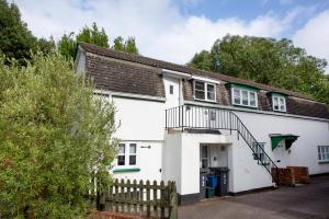 a white house with a wooden fence in front of it at The Hay Loft in Sidmouth