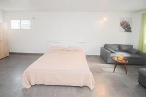 una camera con un grande letto e un divano di La Santa Clara - Studio climatisé a Saint-Pierre