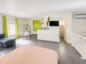 un soggiorno con divano e tavolo e una cucina di La Santa Clara - Studio climatisé a Saint-Pierre