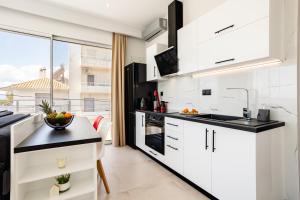 a kitchen with white cabinets and black countertops at Yin & Yang Studio, Marina Hideout in Kalamata (B3) in Kalamata