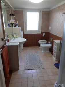 een badkamer met een wastafel, een toilet en een raam bij Villa Elena in Salzano