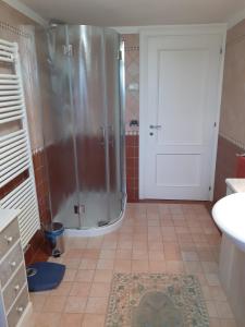 a bathroom with a shower and a white door at Villa Elena in Salzano