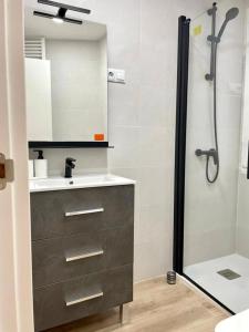 uma casa de banho com um lavatório e um chuveiro com um lavatório. em Soleado em Gijón
