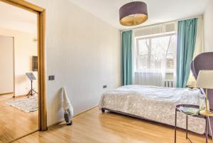 1 dormitorio con cama y espejo en Cozy flat near city center and airport. FREE PARKING en Vilna