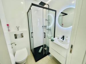 a bathroom with a shower and a toilet and a sink at Âncora - Beach 50m - Sea View Terrace in Armação de Pêra