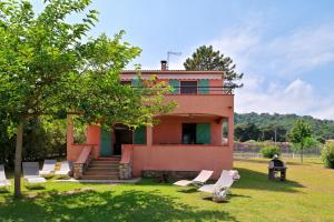 una casa con un montón de sillas delante de ella en Pinea Mare, en Poggio-Mezzana