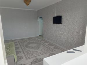 um quarto com uma televisão na parede e um sofá em 2к.апартаменты.7 мкр. em Bishkek