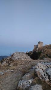 um castelo no topo de uma colina com pedras em Gran Sasso Letizia BB em Filetto