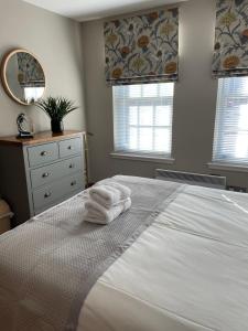 a bedroom with a white bed with towels on it at The Town House in Dornoch