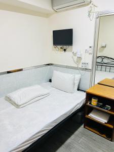 Postel nebo postele na pokoji v ubytování 嘉應賓館HAKKAS GUEST House