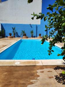 una piscina azul con paredes y árboles azules en El Recreo, private Pool & Bbq, en Godelleta