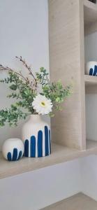 a white and blue vase with flowers on a shelf at Se renta apartamento hermoso amoblado en Ibague sector picaleña in Ibagué