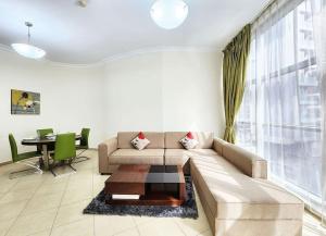 a living room with a couch and a table at RH- Exquisite & Spacious 01 BR, Near Mall of the Emirates in Dubai