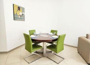 a dining room table with green chairs in a room at RH- Exquisite & Spacious 01 BR, Near Mall of the Emirates in Dubai