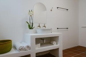 uma casa de banho branca com um lavatório e um espelho em Bonne Esperance, Simon's Town em Simonʼs Town