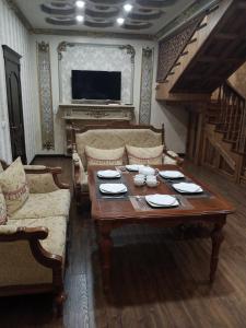 un soggiorno con tavolo e divano di Shafran B&B a Bukhara