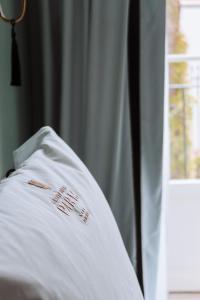 uma camisa branca deitada numa cama com uma janela em GRANDE HOTEL PARIS by STAY HOTELS no Porto