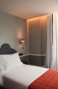 a bedroom with a bed with a red blanket and a window at GRANDE HOTEL PARIS by STAY HOTELS in Porto