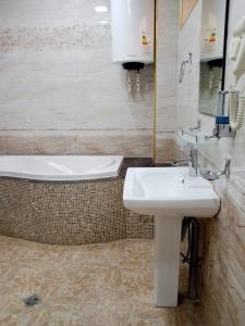 a bathroom with a sink and a bath tub at Shafran B&B in Bukhara