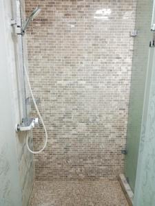 a bathroom with a shower with a tile wall at Shafran B&B in Bukhara