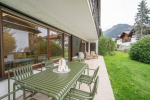 einen grünen Tisch und Stühle auf einer Terrasse in der Unterkunft Edelbude in Oberstdorf