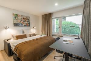 Schlafzimmer mit einem Bett, einem Schreibtisch und einem Fenster in der Unterkunft Edelbude in Oberstdorf