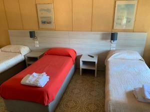 a hotel room with two beds and a red blanket at Cannone d'Oro in Sale