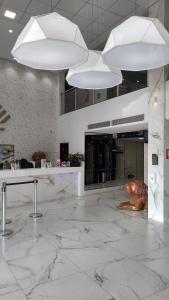 a lobby with white marble floors and white lights at AlphaPark Hotel in Goiânia