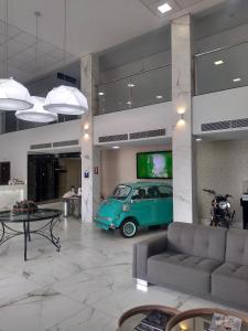 uma sala de estar com um carro verde e uma televisão de ecrã plano em AlphaPark Hotel em Goiânia