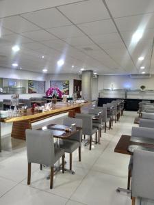 uma sala de jantar com mesas e cadeiras num restaurante em AlphaPark Hotel em Goiânia