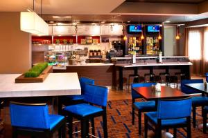 獨立市的住宿－克利夫蘭獨立萬怡酒店，一间设有蓝色椅子的餐厅和一间酒吧