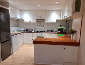 a kitchen with white cabinets and a counter top at Kairos on the Lake in Sedgefield